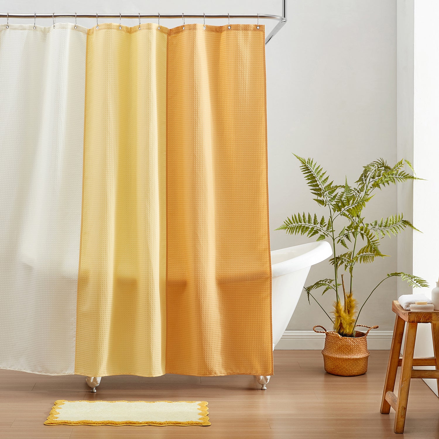 Yellow shower curtain with a plant and wooden stool in a bathroom setting