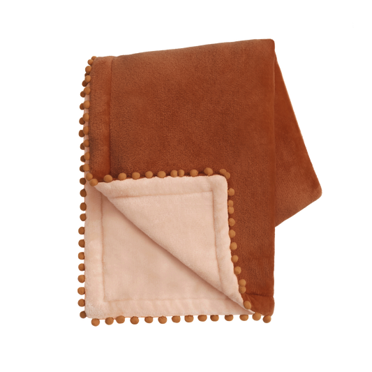 Brown blanket with pom-pom trim on a white background